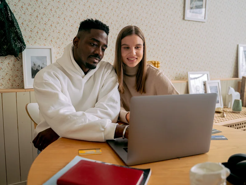 Couple reviewing finances and applying for a loan together at home